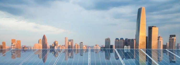 Image depicts city skyline in background reflecting on solar panels in foreground. Image depicts city skyline in background reflecting on solar panels in foreground.