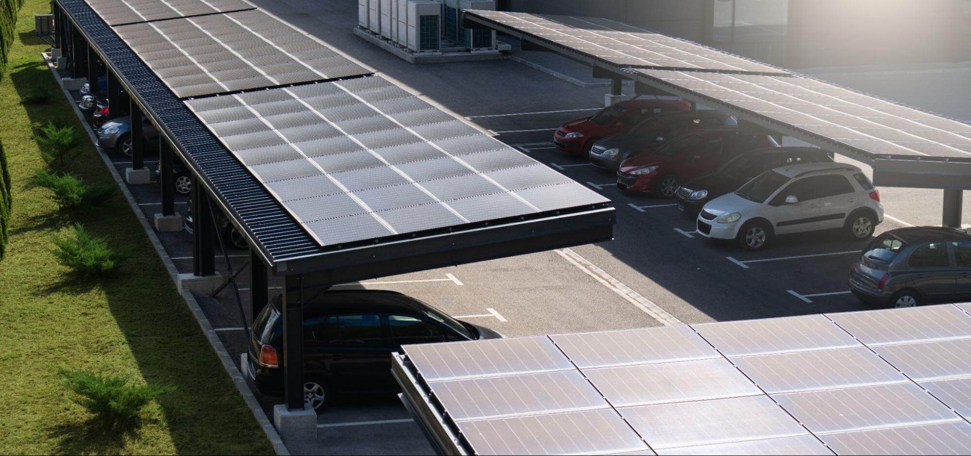 A solar parking canopy, generating low-cost electricity while shading cars over a parking lot for a commercial building.