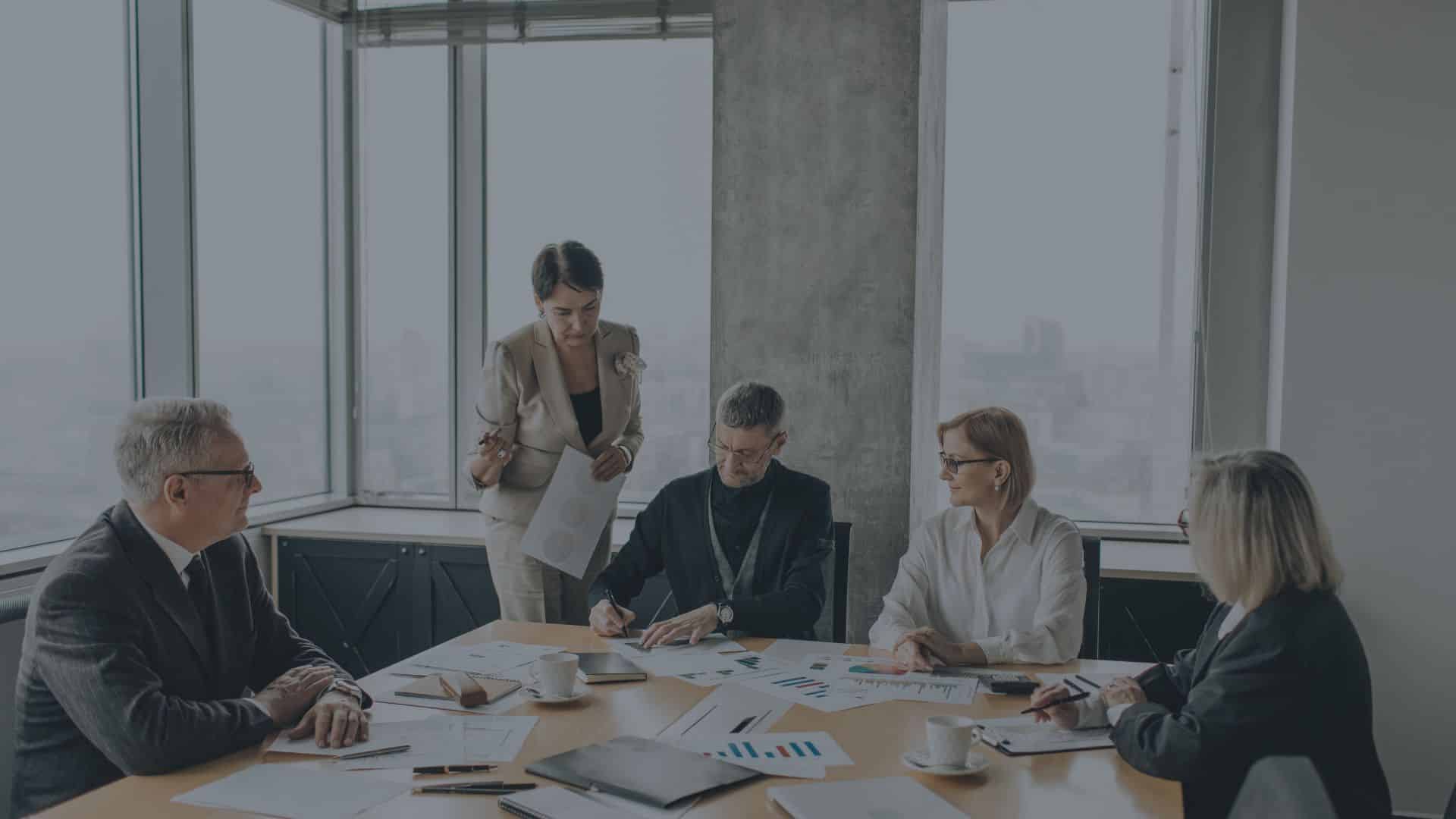 Business team reviewing documents and charts during a meeting in a modern office.